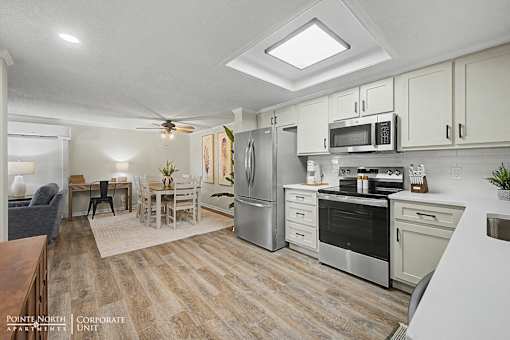 A kitchen with a refrigerator, oven, and microwave.