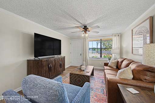 A living room with a brown couch and a flat screen TV.