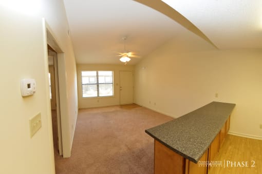the kitchen and living room of an empty house