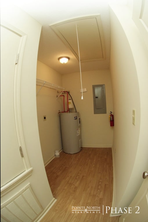 a room with a water heater in the corner of a room