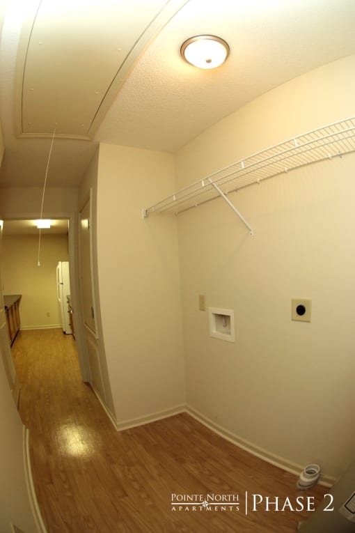 a room with white walls and a wood floor and a white ceiling with a light