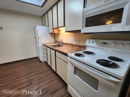 a kitchen with white appliances and white cabinets and a white refrigerator
