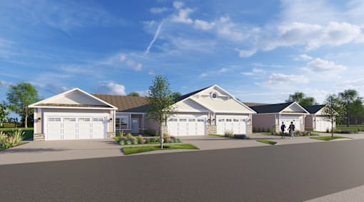 A row of houses with garages are shown in front of a blue sky.