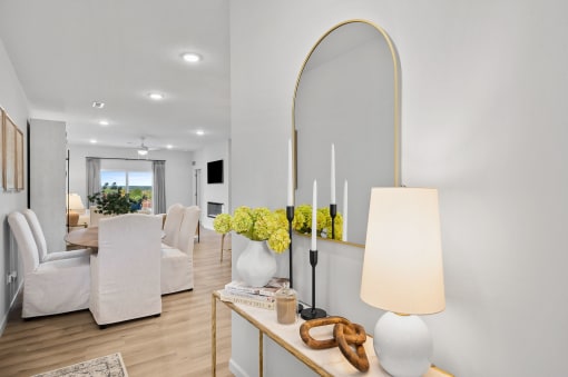 a living room with white furniture and a large mirror