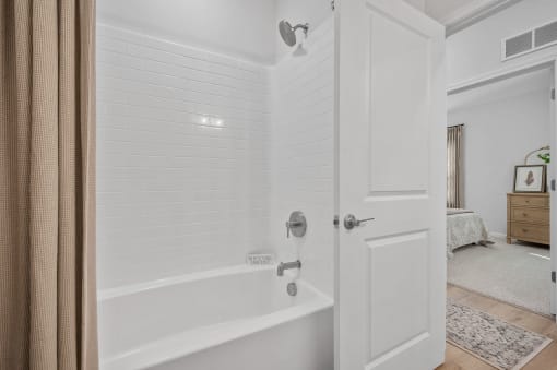 a white bathroom with a shower and a tub