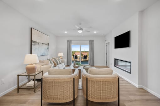 a living room with a couch and chairs and a ceiling fan