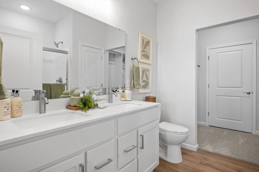 a white bathroom with a large mirror and a toilet
