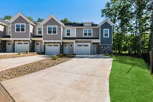 A row of houses with garages and driveways.