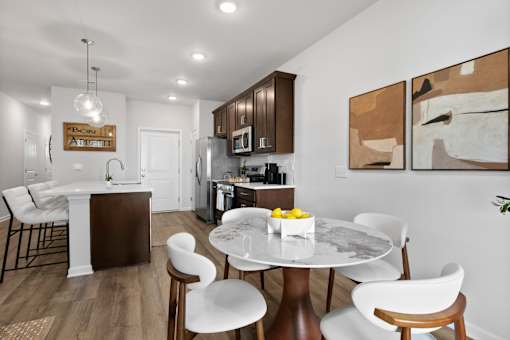 A modern kitchen with a dining table set for two.