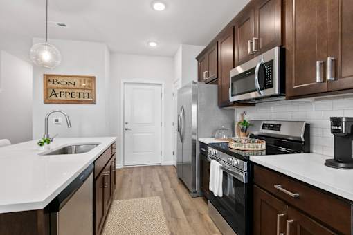 A kitchen with a white counter top and a sign that says Bon Appetit.