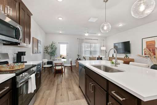 A modern kitchen with dark wood cabinets and white countertops.
