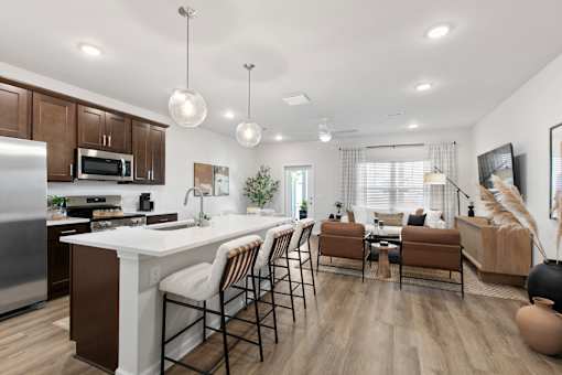 A modern kitchen with a dining area and a living room.