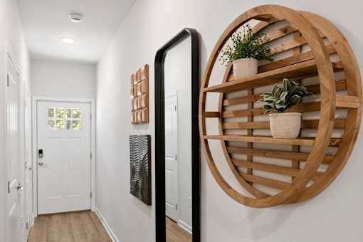 A white door is on the left and a wooden shelf is on the right.