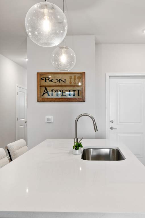 A kitchen with a white counter top and a sink.