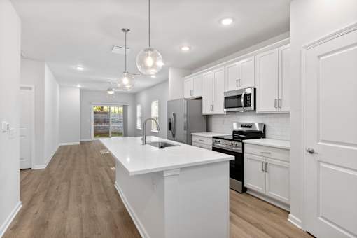 A modern kitchen with white cabinets and a large island.