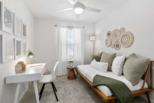 A bedroom with a bed, desk, and chair.