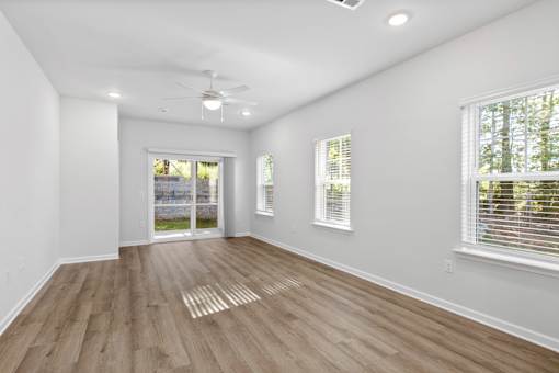 A room with wooden flooring and white walls.