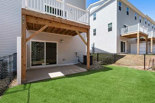 A white house with a wooden deck and glass door.