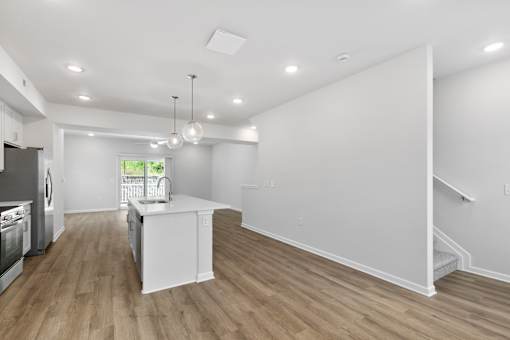 A kitchen with white cabinets and a wooden floor.