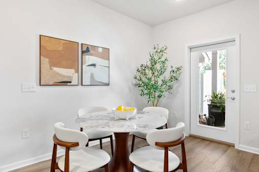 A dining room with a white table and chairs.