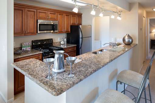 A kitchen with granite countertops and wooden cabinets.