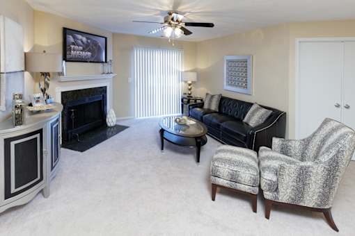A living room with a fireplace, a couch, and a chair.
