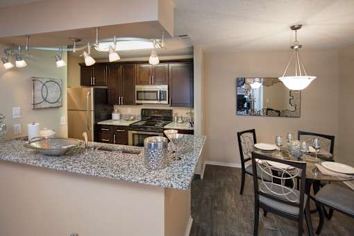 A kitchen with a dining table set for two.