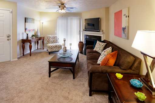 A living room with a brown couch, a coffee table, and a flat screen TV.