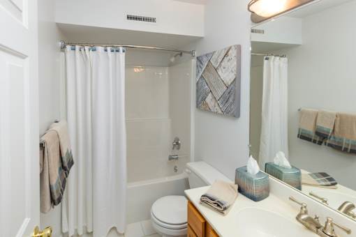 A white bathroom with a toilet, sink, and shower.