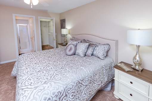 A bedroom with a bed, nightstand, and lamp.