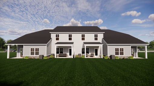 A large white house with a black roof and a covered porch.