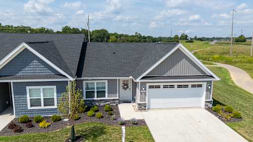 A house with a grey roof and a white garage door.
