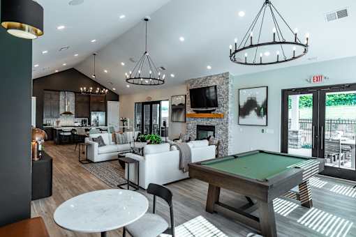 A well-lit, spacious living room with a pool table and comfortable seating.