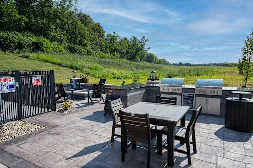 A patio with a table and chairs is surrounded by a fence with a sign that reads "Dangerous Property".