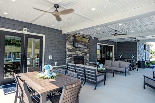 A modern outdoor dining area with a wooden table and chairs.