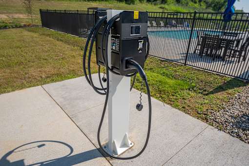 A charging station for electric vehicles is located on a concrete pad.