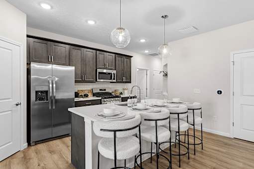A modern kitchen with a large island and stools.