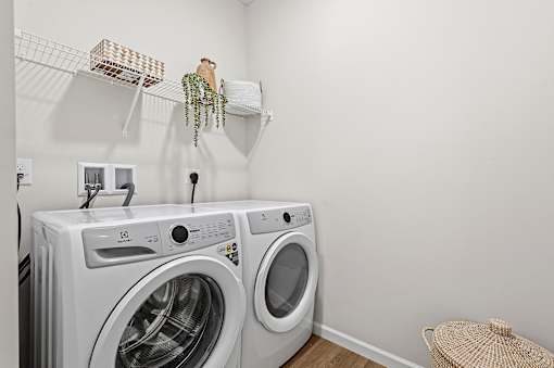 A white washing machine and dryer in a laundry room.
