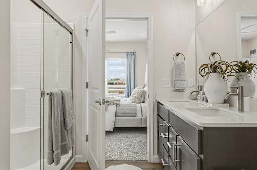 A bathroom with a white door and a mirror.