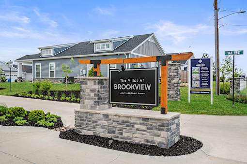 A sign for The Villas at Brookview Apartment Homes stands in front of a building.