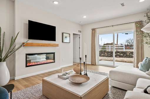 A modern living room with a fireplace and a flat screen TV mounted above it.
