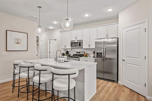 A modern kitchen with white cabinets and a central island.
