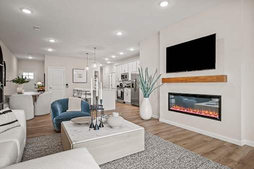 A modern living room with a fireplace and a flat screen TV mounted on the wall.