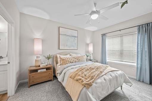 A bedroom with a large bed and a ceiling fan.