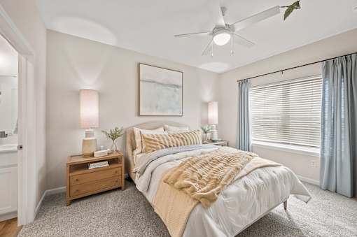 A bedroom with a large bed and a ceiling fan.