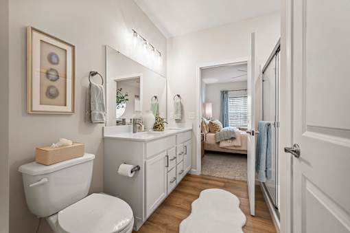 A white bathroom with a toilet, sink, and mirror.