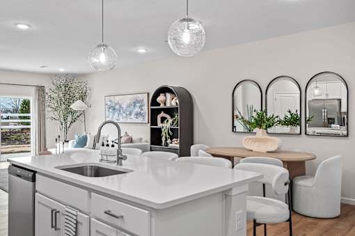 A modern kitchen with a large island and a dining area.