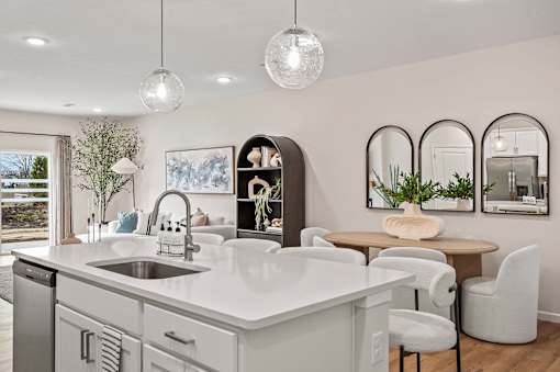 A modern kitchen with a large island and a dining area.