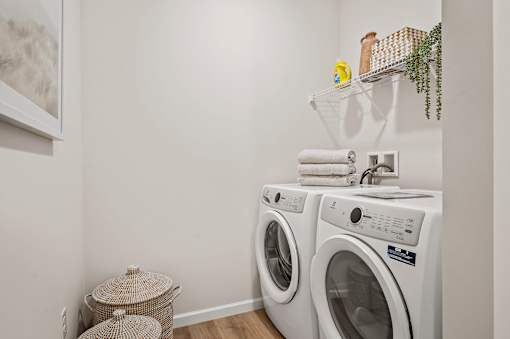 A white laundry room with a washer and dryer stacked on top of each other.