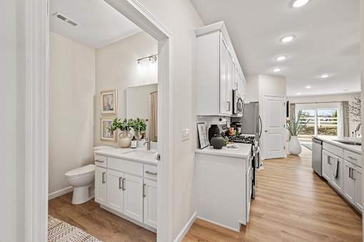 A white bathroom with a toilet, sink, and mirror.